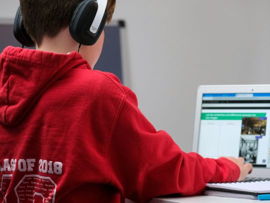 boy in red hoodie wearing black headphones