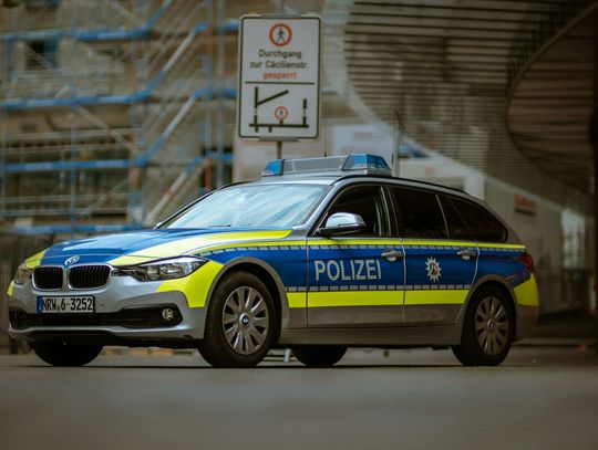 blue and yellow police car on road