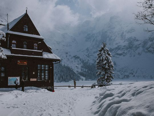 a cabin in the mountains covered in snow