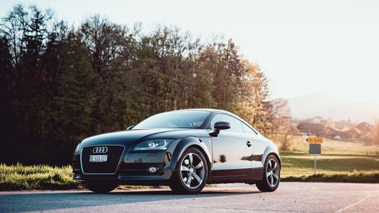 black Audi coupe parked on gray concrete road